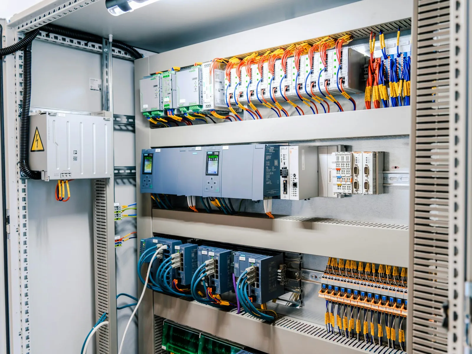 Cuadro de control industrial abierto, con autómata, módulos de entradas y salidas y switches de red